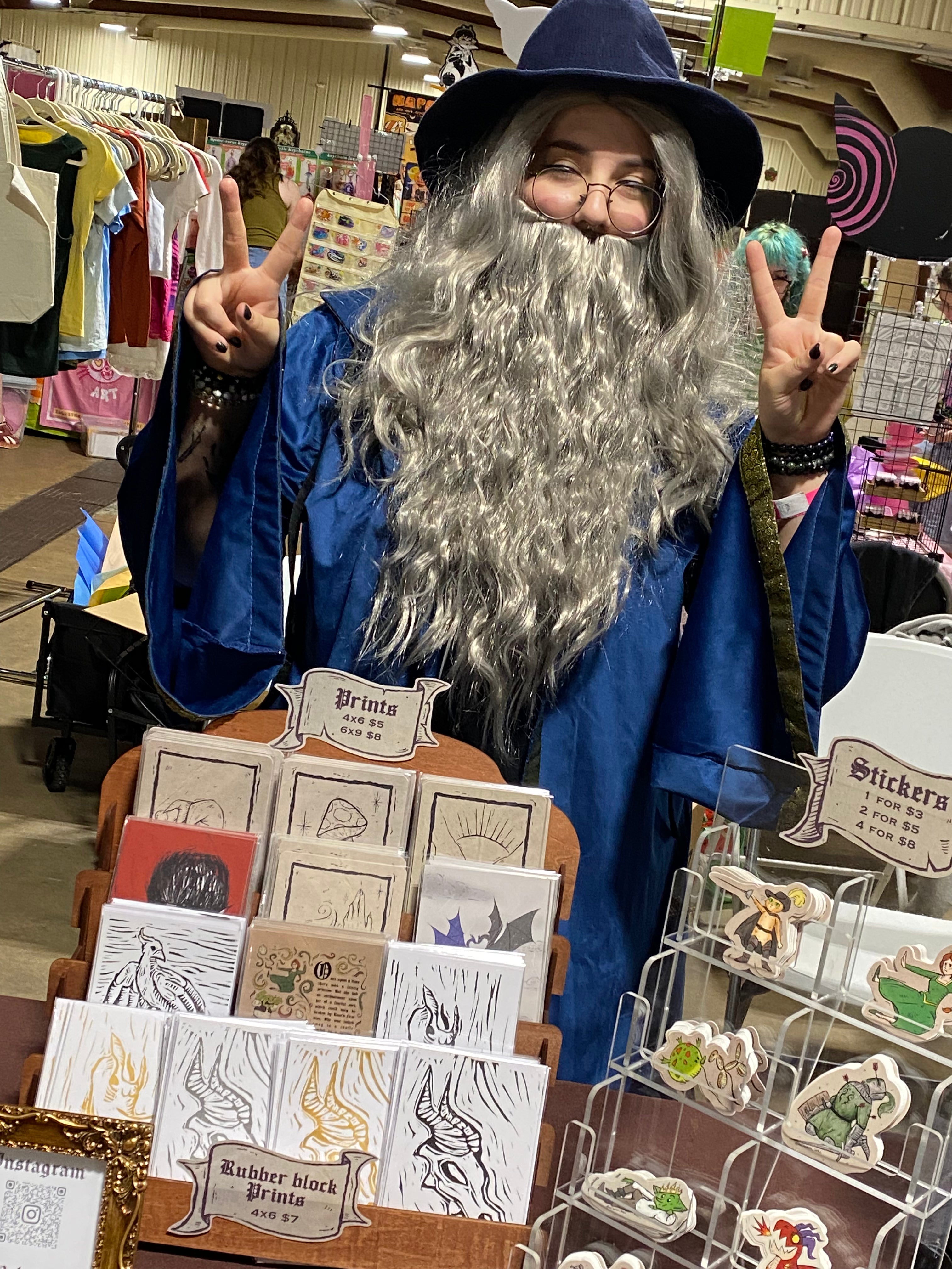 Me in a wizard costume with merchandise at a market
