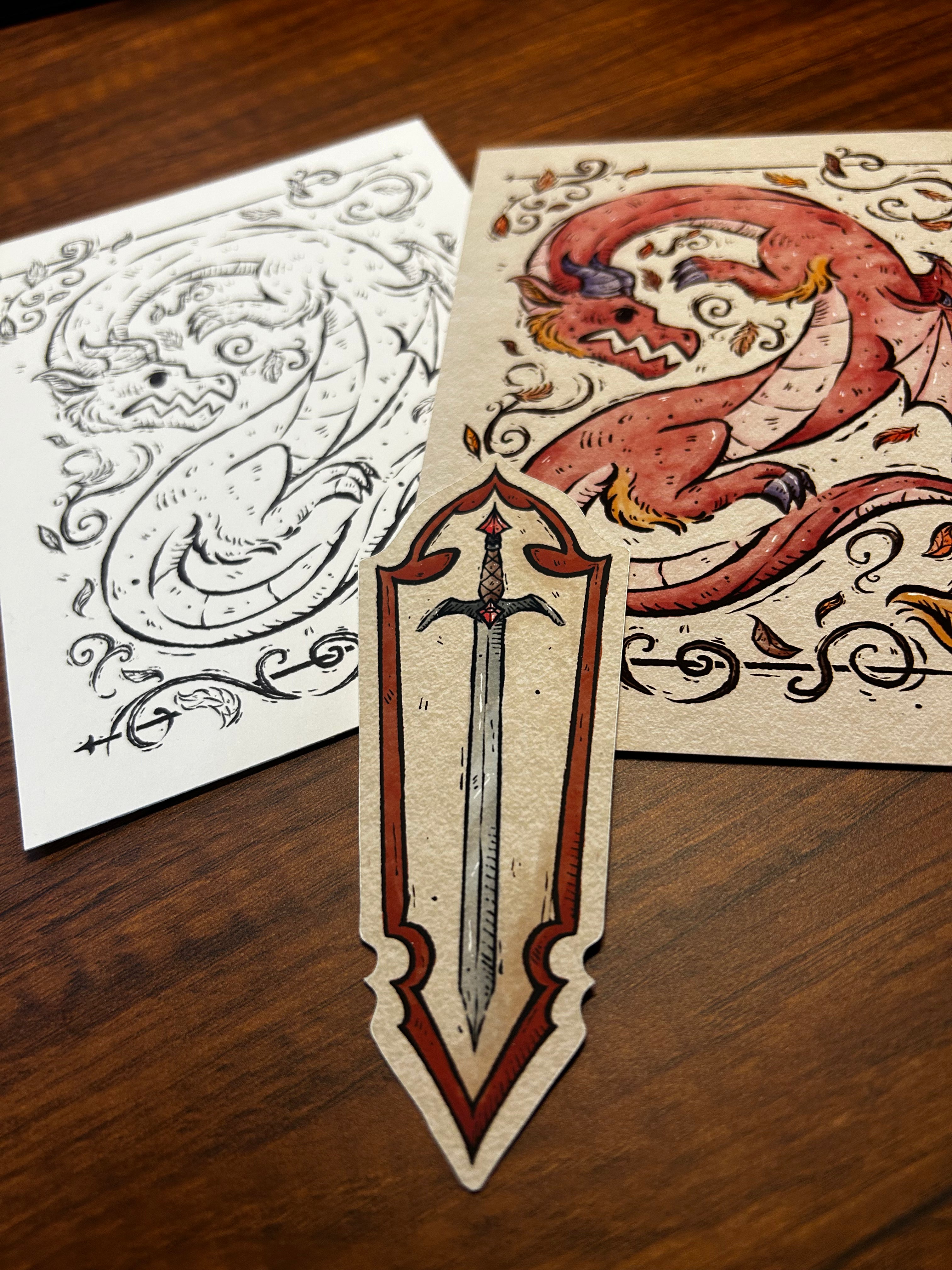 Decorative sword bookmark and dragon print and coloring page on a wooden surface
